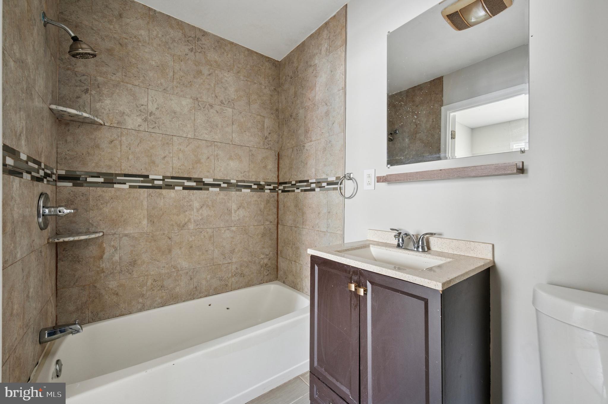 424 North 64th Street Philadelphia, PA 19151 - Photo 14 of 35 a bathroom with a sink a mirror and a bathtub