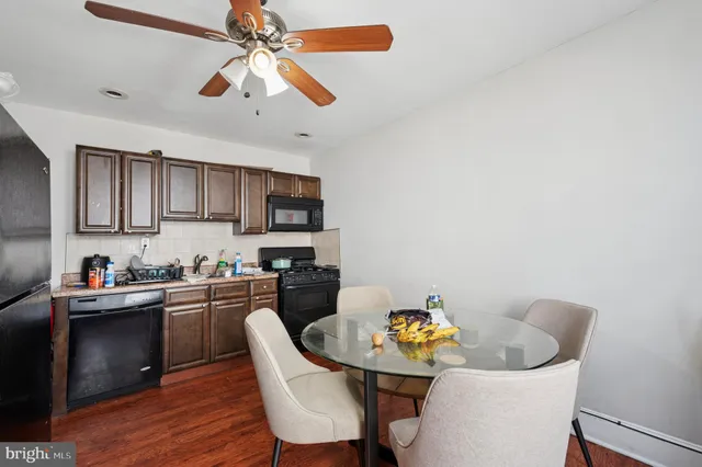 a kitchen with stainless steel appliances granite countertop a dining table and chairs