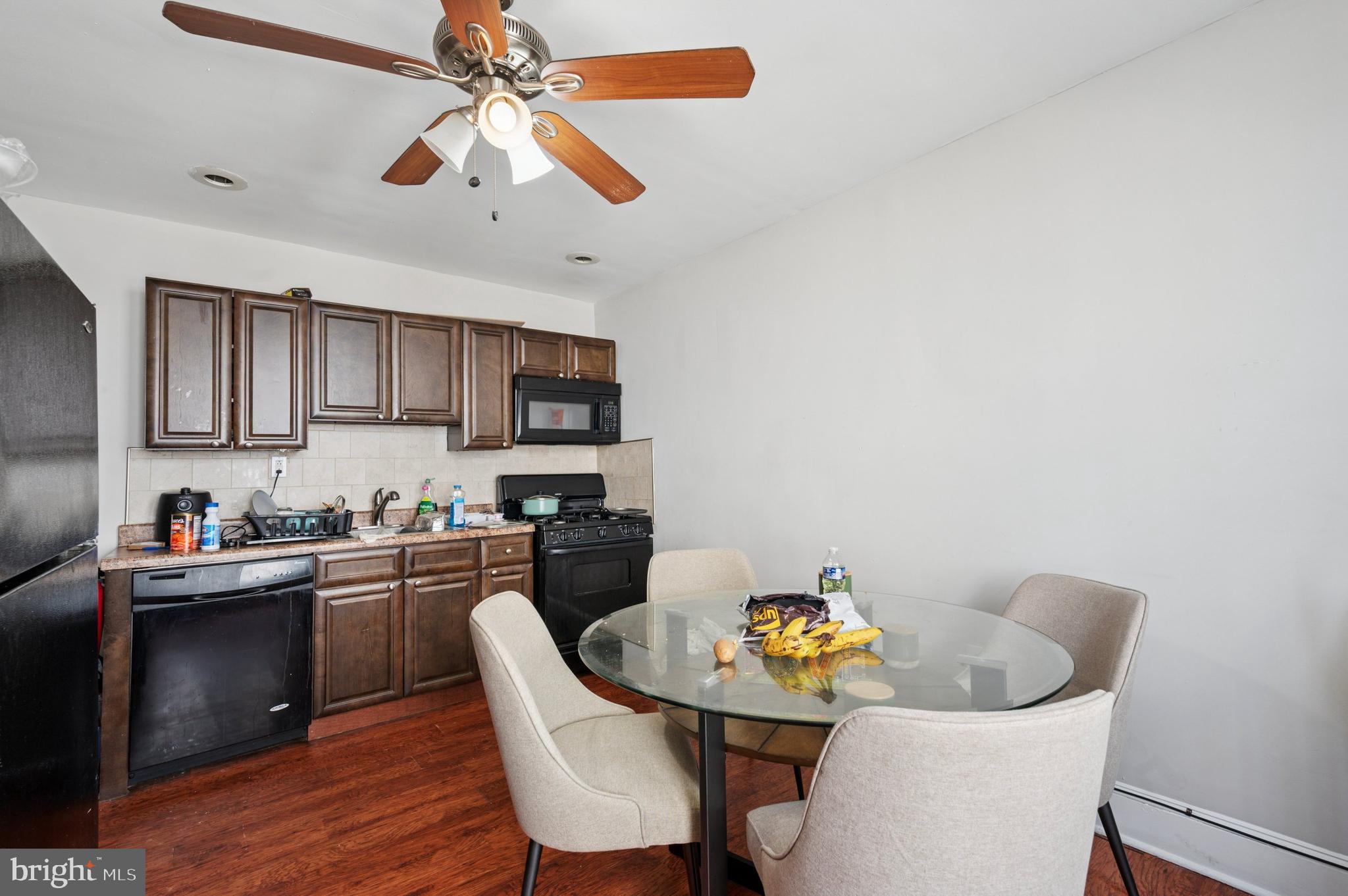 424 North 64th Street Philadelphia, PA 19151 - Photo 19 of 35 a kitchen with stainless steel appliances granite countertop a dining table chairs stove a sink and dishwasher