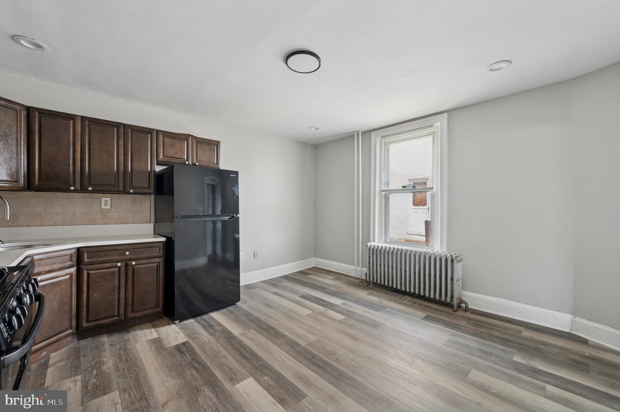 424 North 64th Street Philadelphia, PA 19151 - Photo 10 of 35 a kitchen with refrigerator cabinets and wooden floor