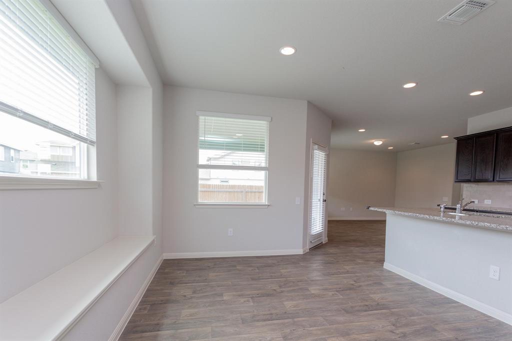 14614 Frankel Loop Pflugerville, TX 78660 - Photo 5 of 15 A window-lined breakfast nook with a built-in bench transitions seamlessly into a well-appointed kitchen.