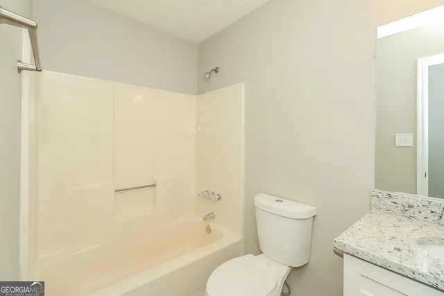 a white toilet sitting next to a bath tub