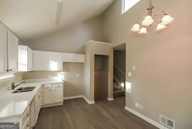 a view of a kitchen with a sink cabinets and wooden floor