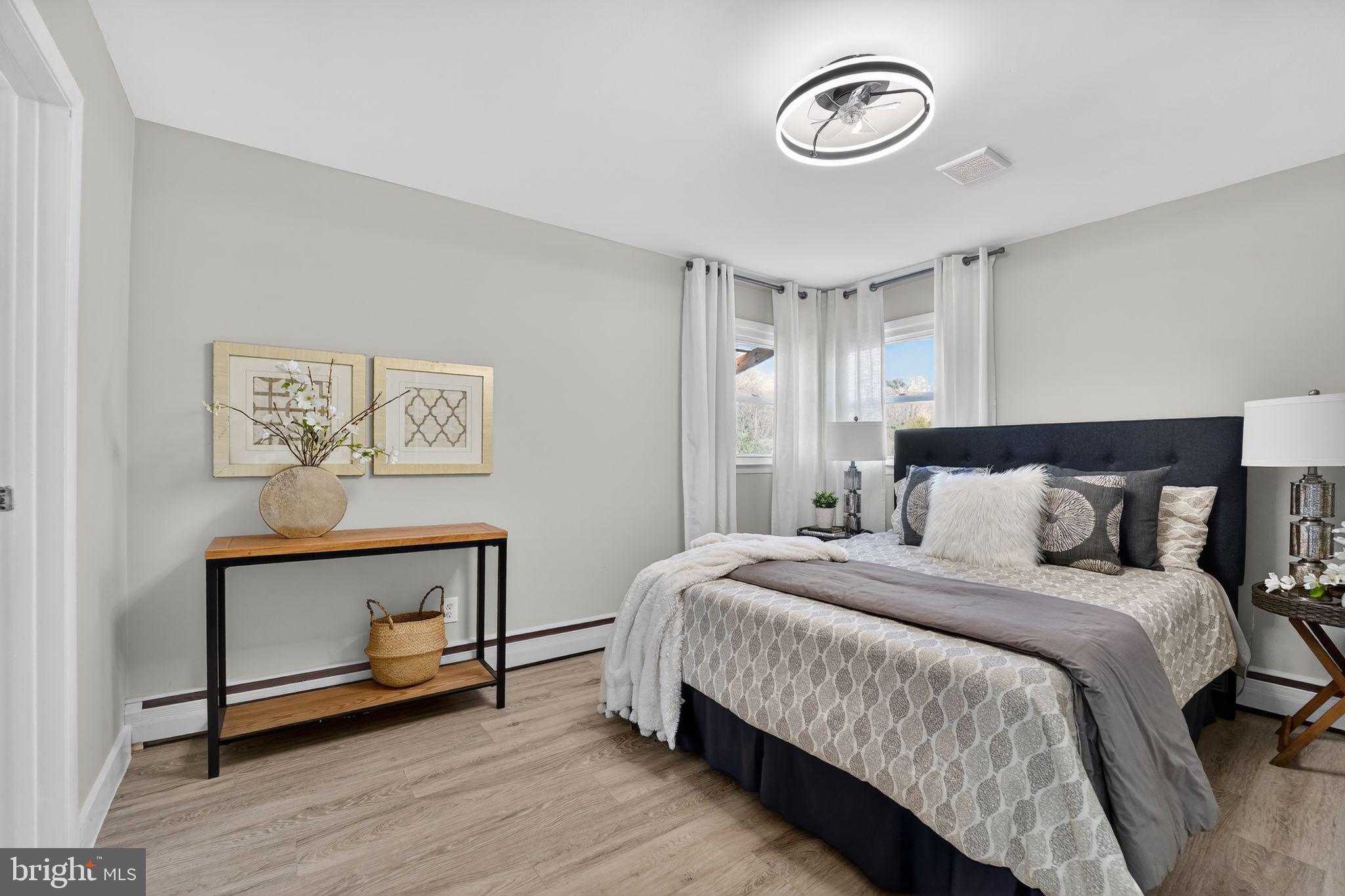 9337 Millbrook Road Ellicott City, MD 21042 - Photo 12 of 33 a bedroom with a bed and a chandelier