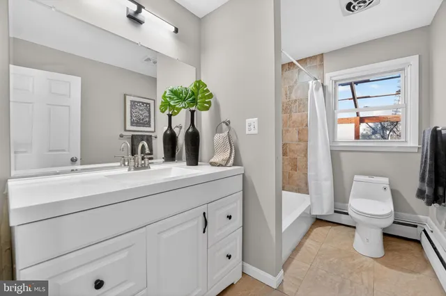 a spacious bathroom with a toilet sink and mirror