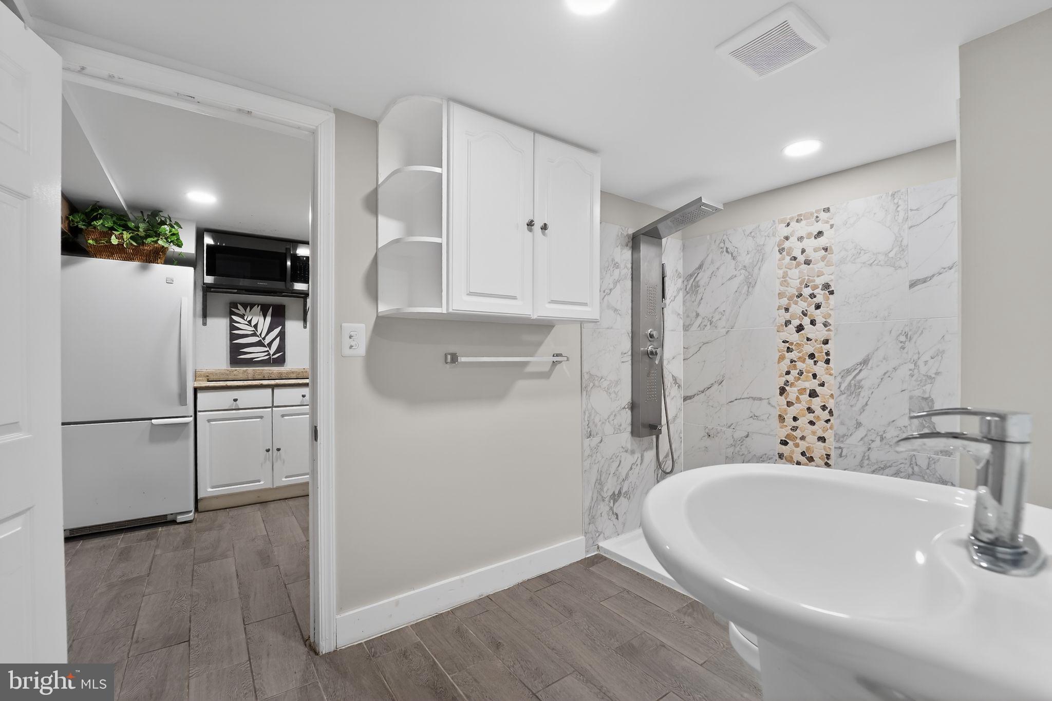 9337 Millbrook Road Ellicott City, MD 21042 - Photo 21 of 33 a bathroom with a bathtub and a sink
