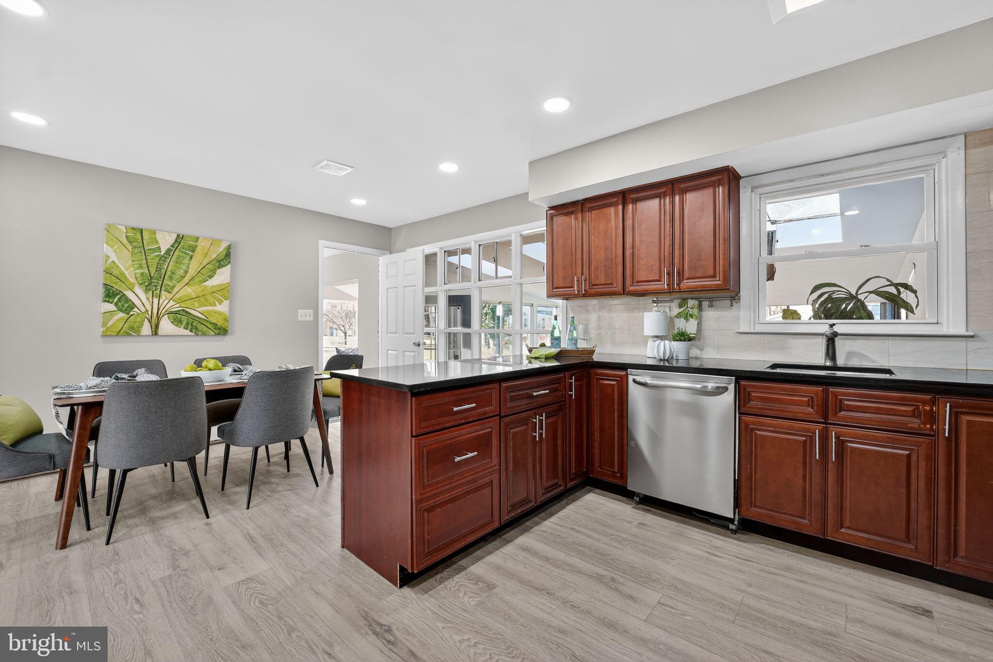 9337 Millbrook Road Ellicott City, MD 21042 - Photo 5 of 33 a kitchen with stainless steel appliances granite countertop wooden cabinets a dining table and chairs