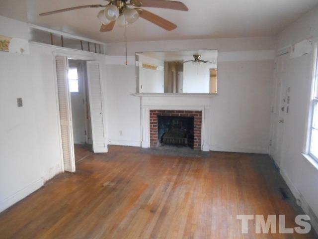 432 Peyton Street Raleigh, NC 27610 - Photo 4 of 12 an empty room with windows and fireplace