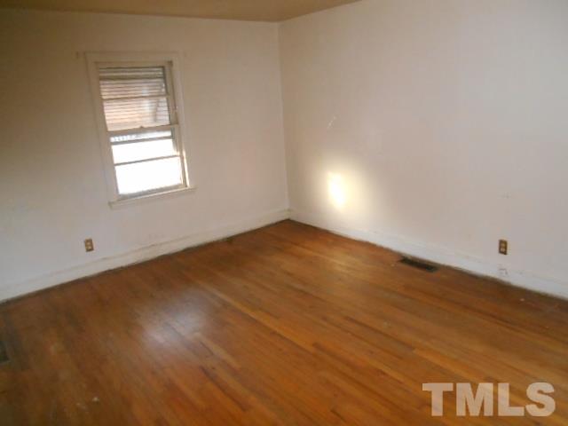 432 Peyton Street Raleigh, NC 27610 - Photo 7 of 12 an empty room with wooden floor and windows
