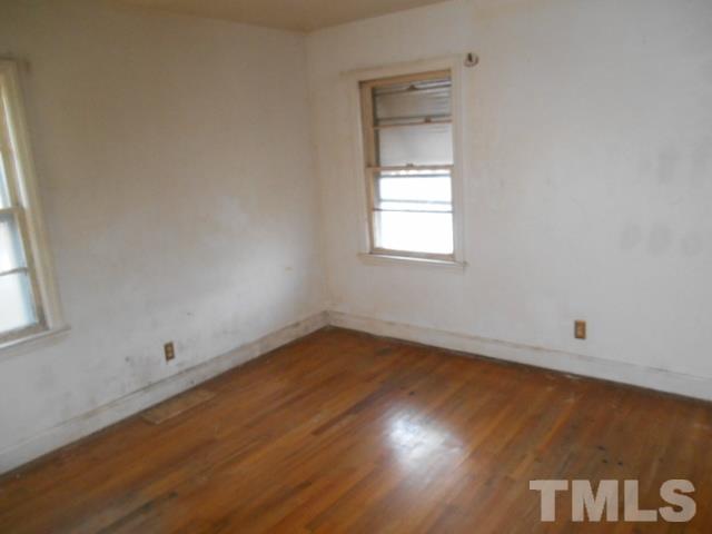 432 Peyton Street Raleigh, NC 27610 - Photo 9 of 12 an empty room with wooden floor and windows
