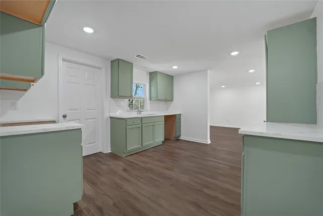 a view of a kitchen with sink and wooden floor