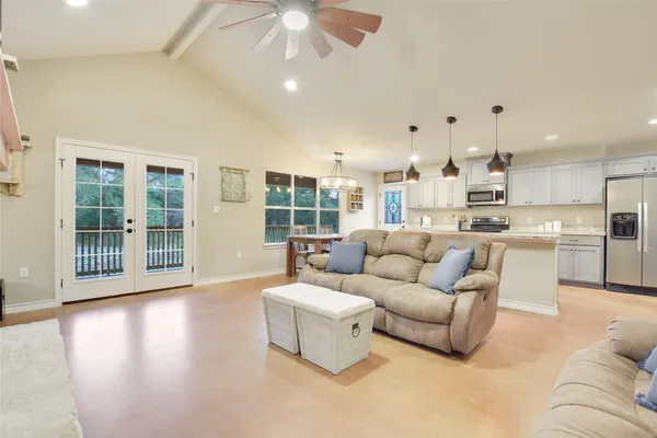 a living room with furniture and a view of kitchen