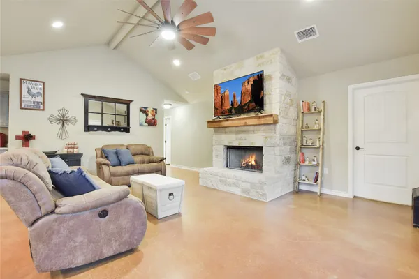 a kitchen with stainless steel appliances granite countertop a stove a sink a refrigerator and white cabinets with wooden floor