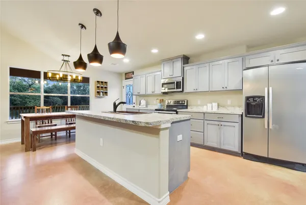 a kitchen with granite countertop white cabinets and stainless steel appliances