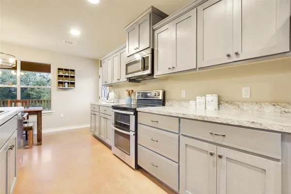 a kitchen with microwave a stove and furniture