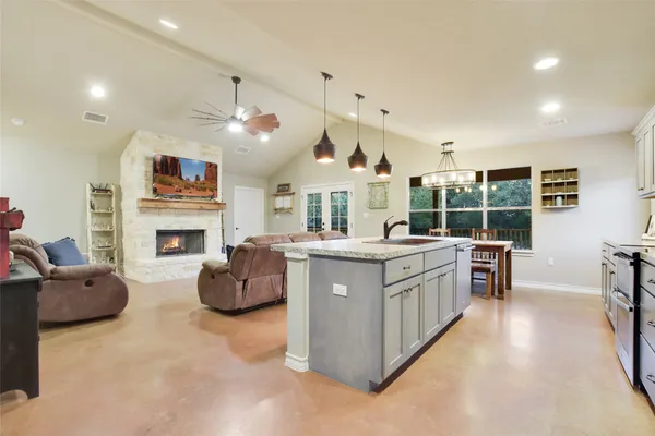 a spacious bedroom with a bed a chandelier and dresser