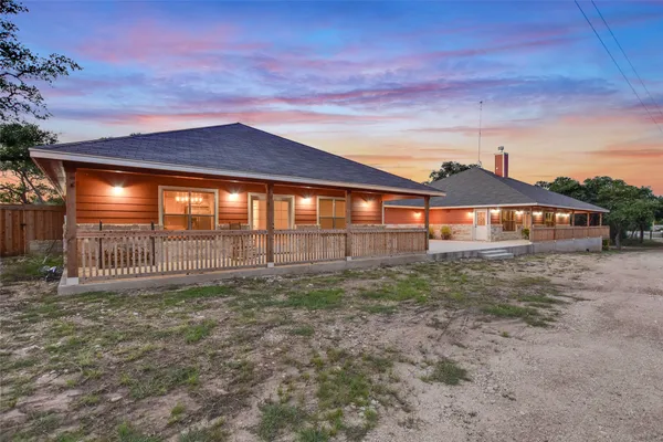 a view of a house with a yard and large tree