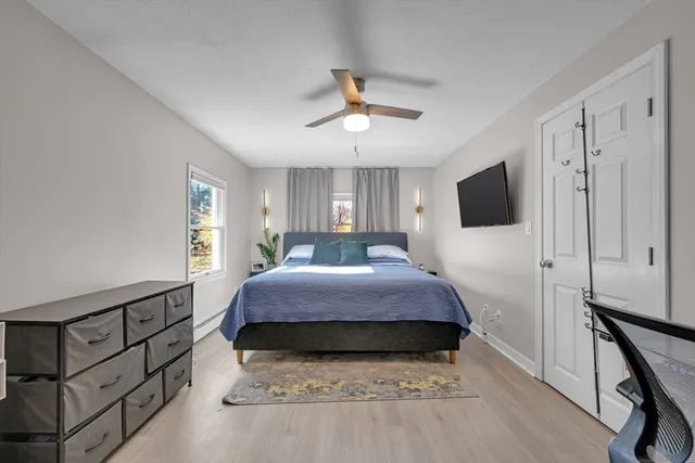 a bedroom with a bed and a flat tv screen on the dresser
