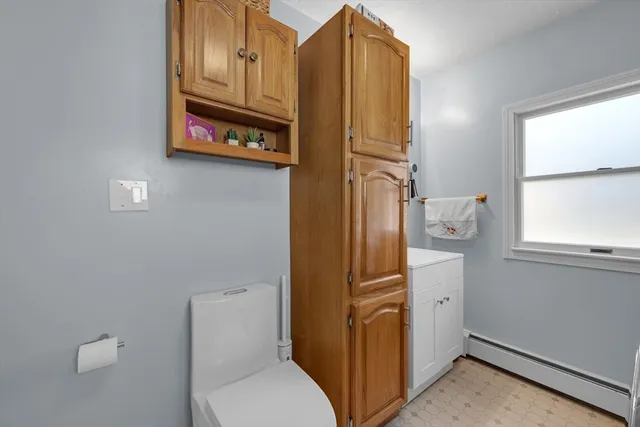 a bathroom with a sink a toilet and a window