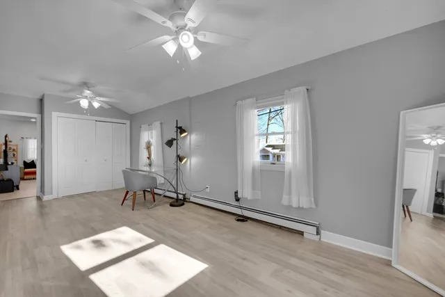 a view of a livingroom with a piano and wooden floor