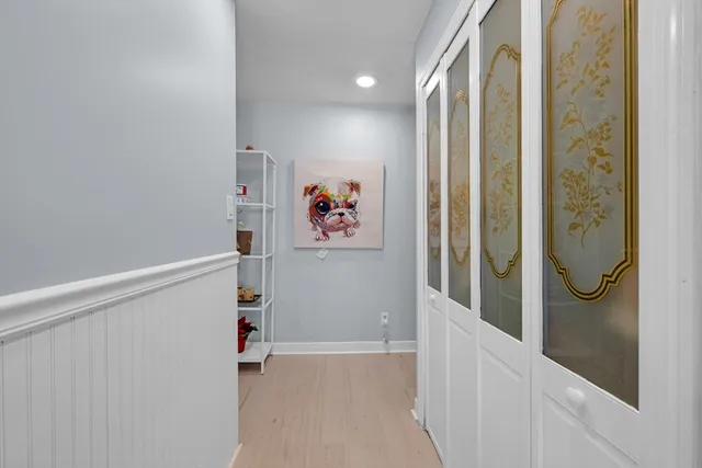 a view of a hallway with wooden floor and closet
