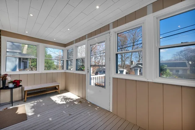 a living room with stainless steel appliances wooden floor and large window