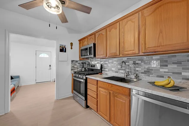 a kitchen with stainless steel appliances granite countertop a sink a stove cabinets and a refrigerator