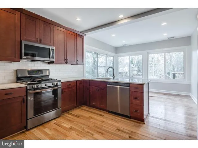 a kitchen with stainless steel appliances granite countertop a stove a sink and a microwave