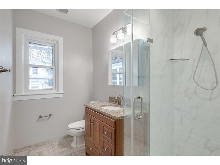 309-311 Warwick Road Haddonfield, NJ 08033 - Photo 6 of 11 a bathroom with a granite countertop sink toilet a mirror and shower