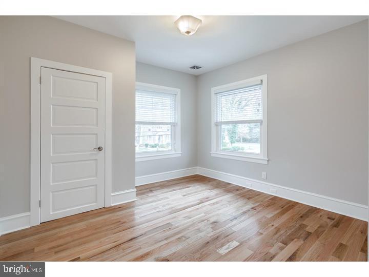 309-311 Warwick Road Haddonfield, NJ 08033 - Photo 9 of 12 wooden floor in an empty room with a window