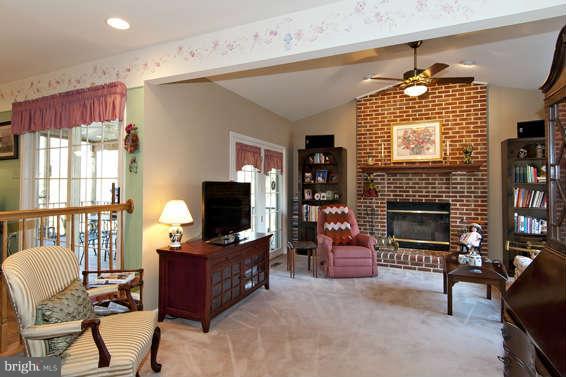 3721 Ligon Road Ellicott City, MD 21042 - Photo 17 of 30 a living room with furniture a fireplace and a flat screen tv