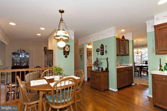 3721 Ligon Road Ellicott City, MD 21042 - Photo 19 of 30 a dining room with wooden floor a chandelier a wooden table and chairs