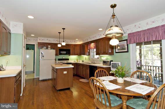 3721 Ligon Road Ellicott City, MD 21042 - Photo 4 of 30 a kitchen with a table chairs sink and wooden floor