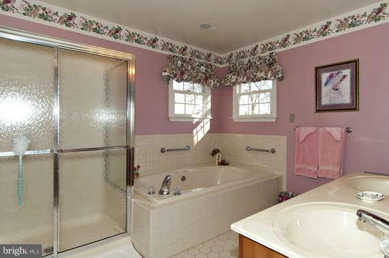 3721 Ligon Road Ellicott City, MD 21042 - Photo 7 of 30 a bathroom with a tub sink and mirror