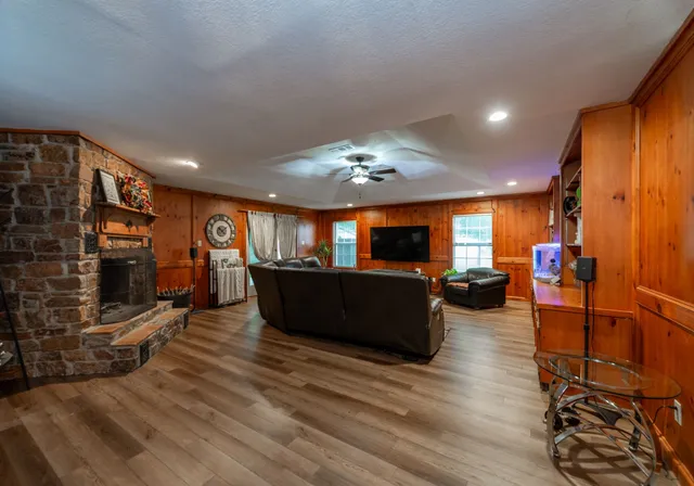 a large living room with furniture a flat screen tv and a fireplace