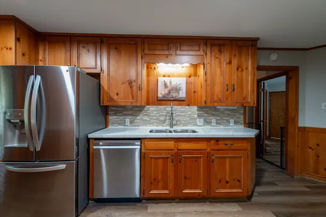 a kitchen with kitchen island a counter top space cabinets and stainless steel appliances