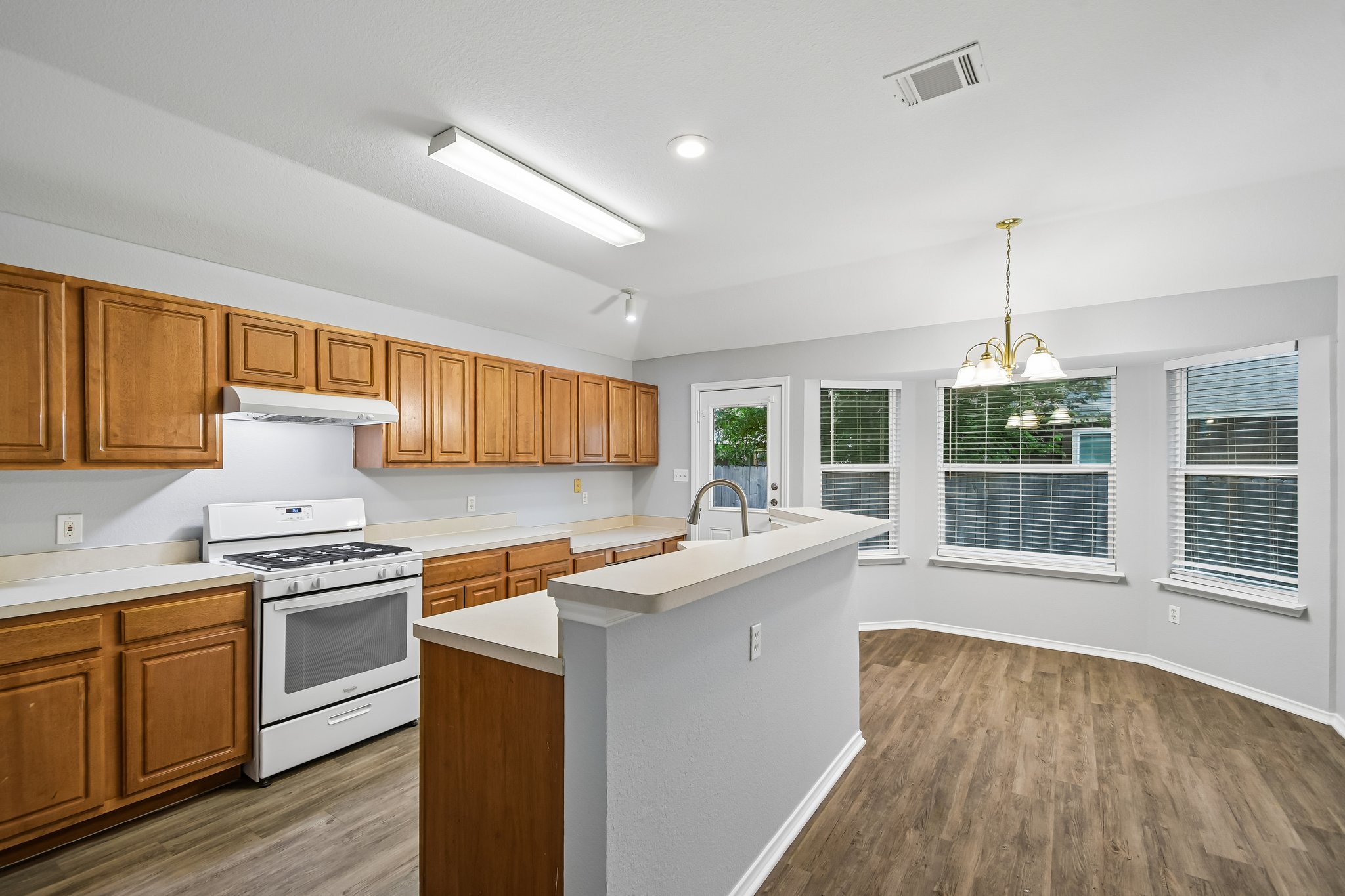 205 Cavalry Trail Elgin, TX 78621 - Photo 11 of 32 a kitchen with a sink stove and wooden cabinets