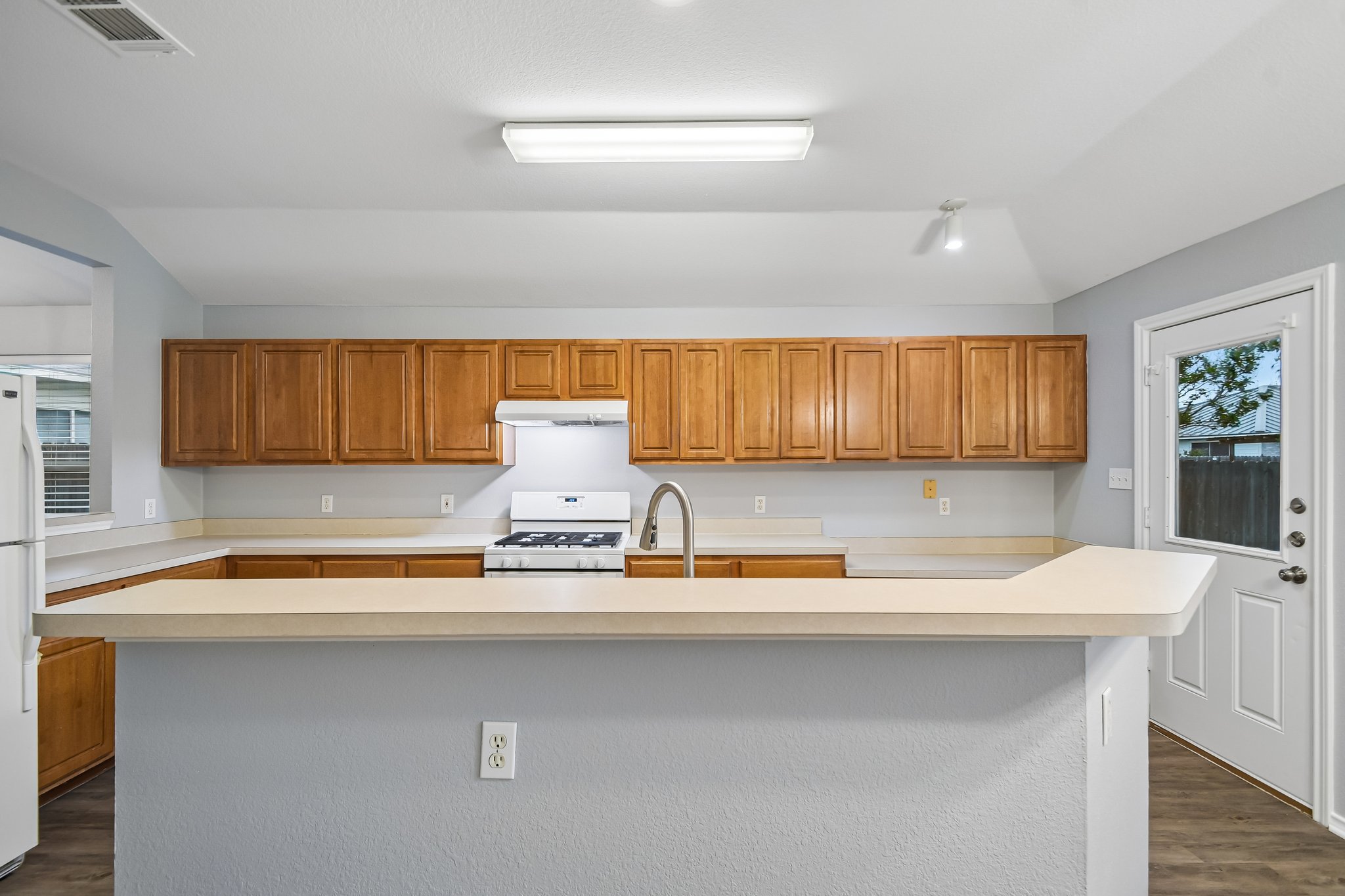 205 Cavalry Trail Elgin, TX 78621 - Photo 12 of 32 a kitchen with a sink and a potted plant with wooden floor