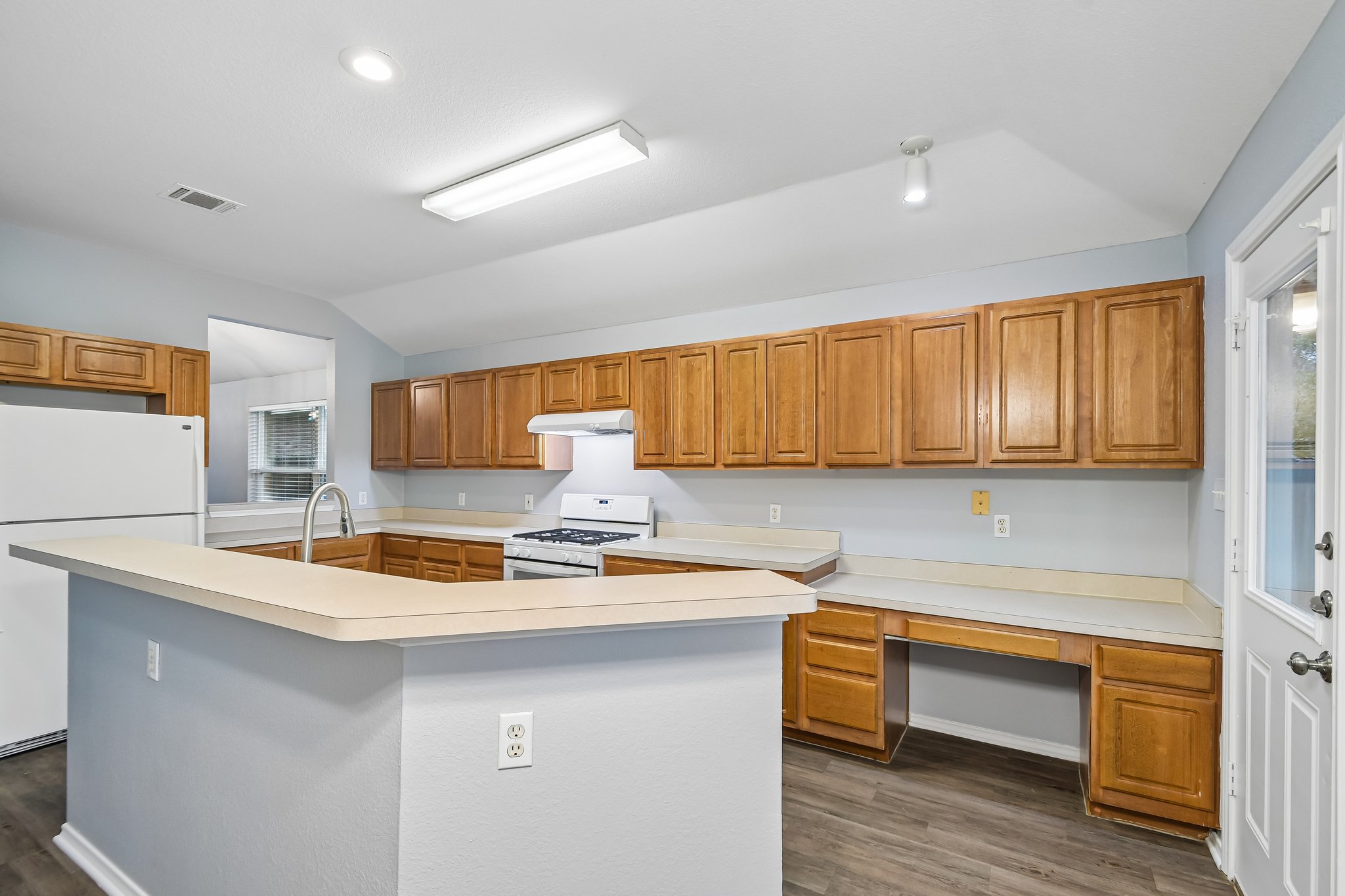 205 Cavalry Trail Elgin, TX 78621 - Photo 13 of 32 a kitchen with stainless steel appliances granite countertop a sink dishwasher a stove and a refrigerator with wooden cabinets