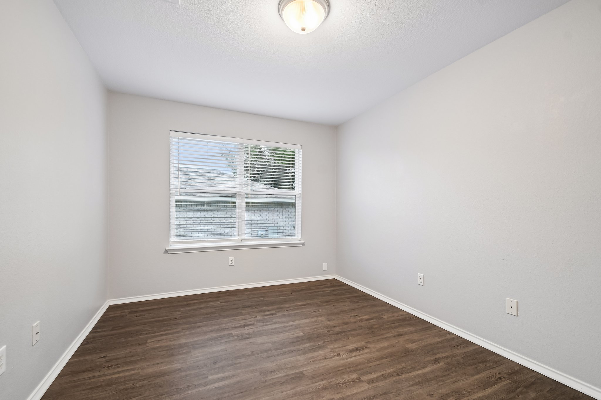 205 Cavalry Trail Elgin, TX 78621 - Photo 24 of 32 an empty room with wooden floor and windows