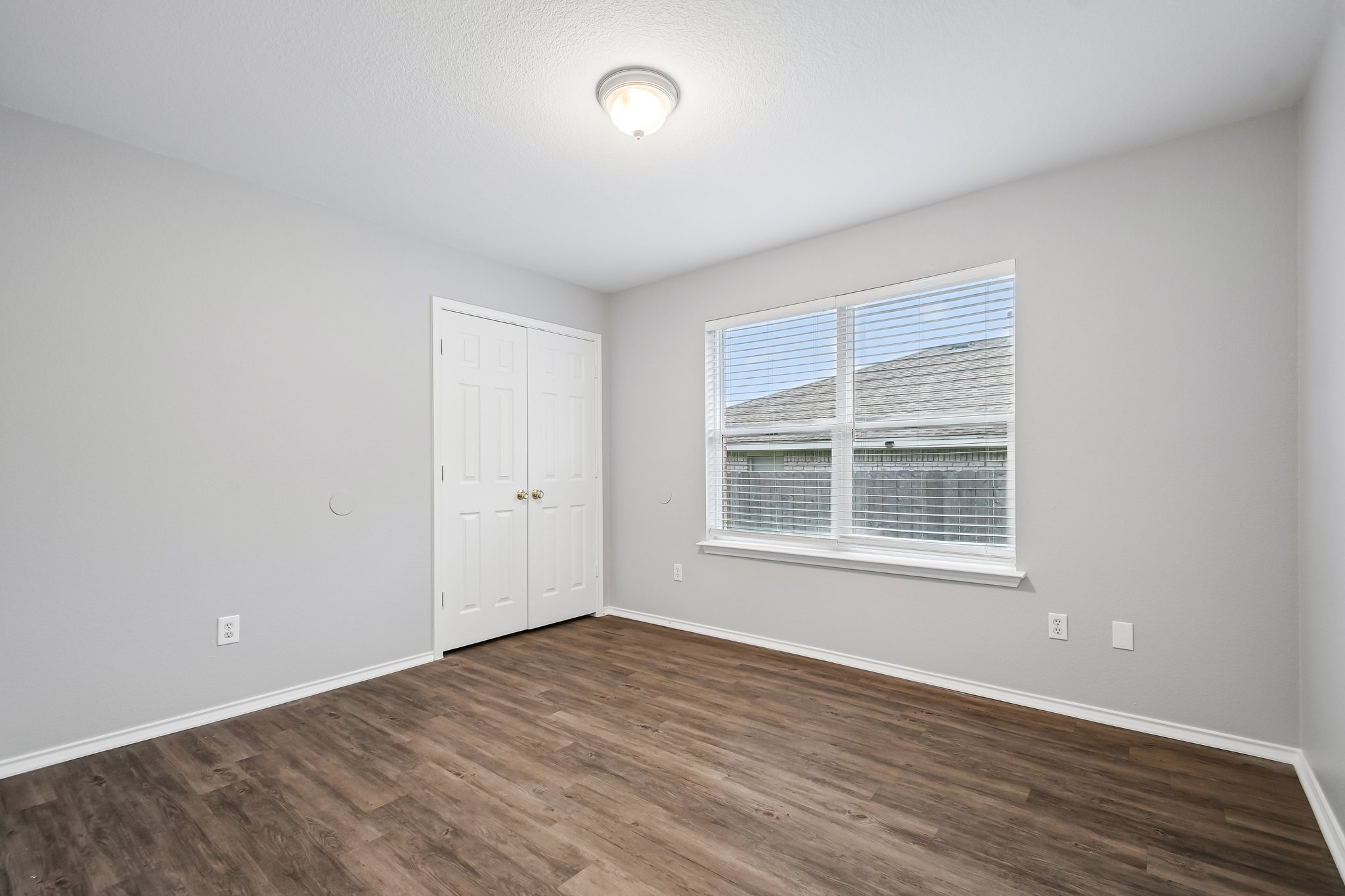 205 Cavalry Trail Elgin, TX 78621 - Photo 27 of 32 an empty room with wooden floor and windows
