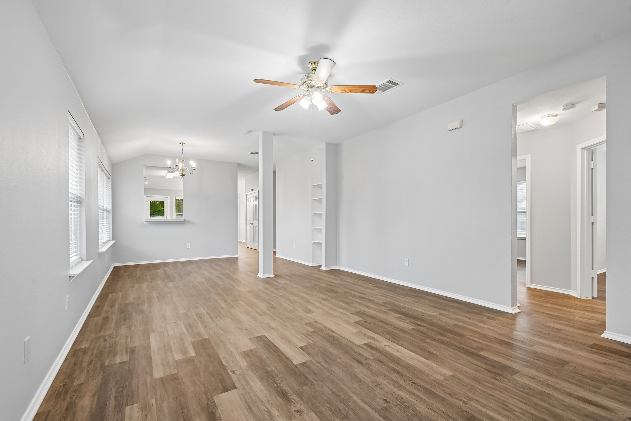 205 Cavalry Trail Elgin, TX 78621 - Photo 5 of 32 a view of an empty room with wooden floor and a ceiling fan
