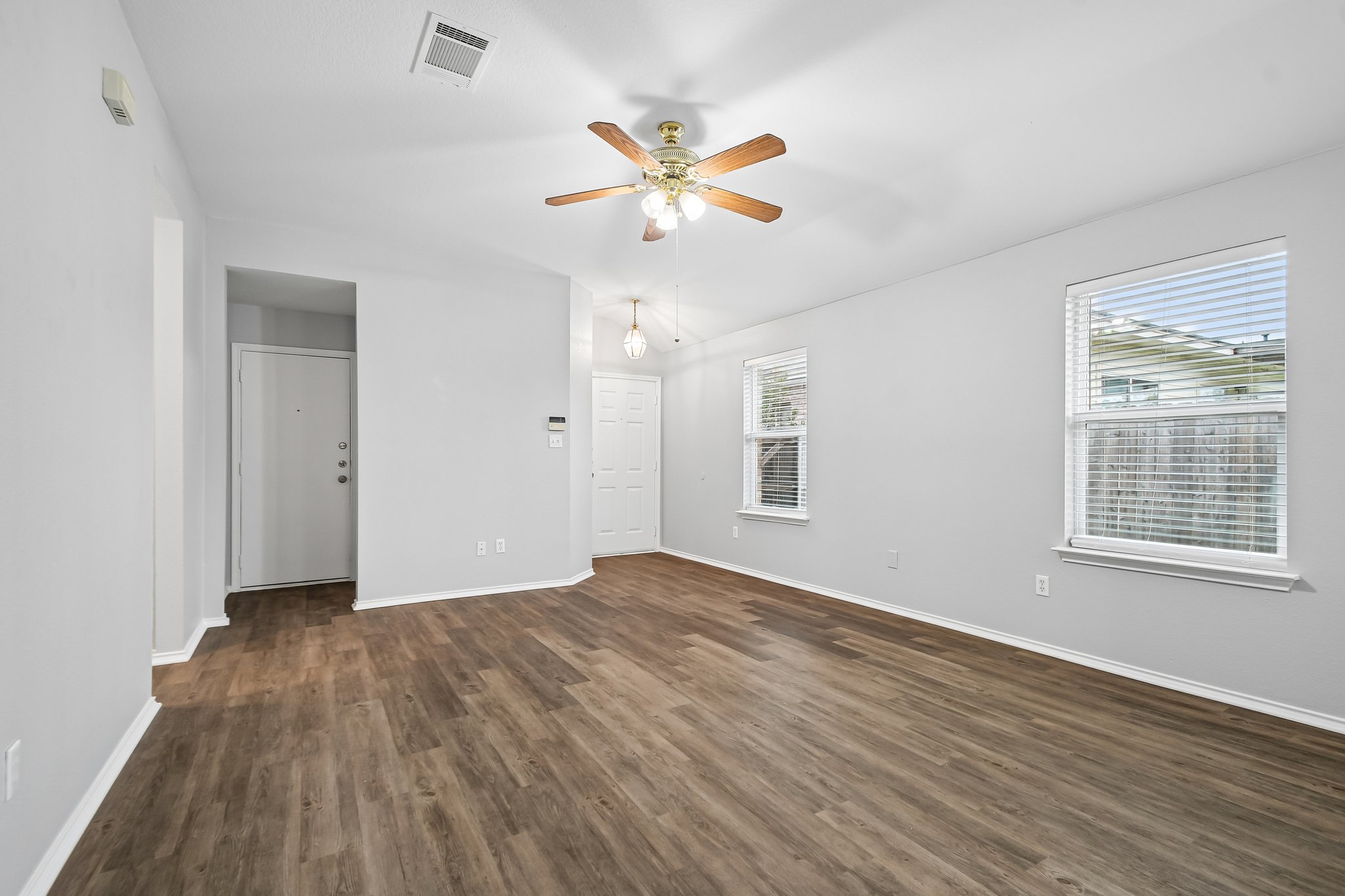 205 Cavalry Trail Elgin, TX 78621 - Photo 7 of 32 a view of an empty room with wooden floor and a window