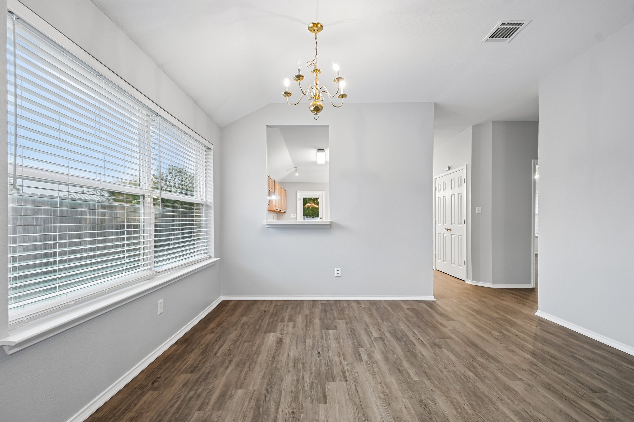 205 Cavalry Trail Elgin, TX 78621 - Photo 9 of 32 a view of an empty room with a window and wooden floor