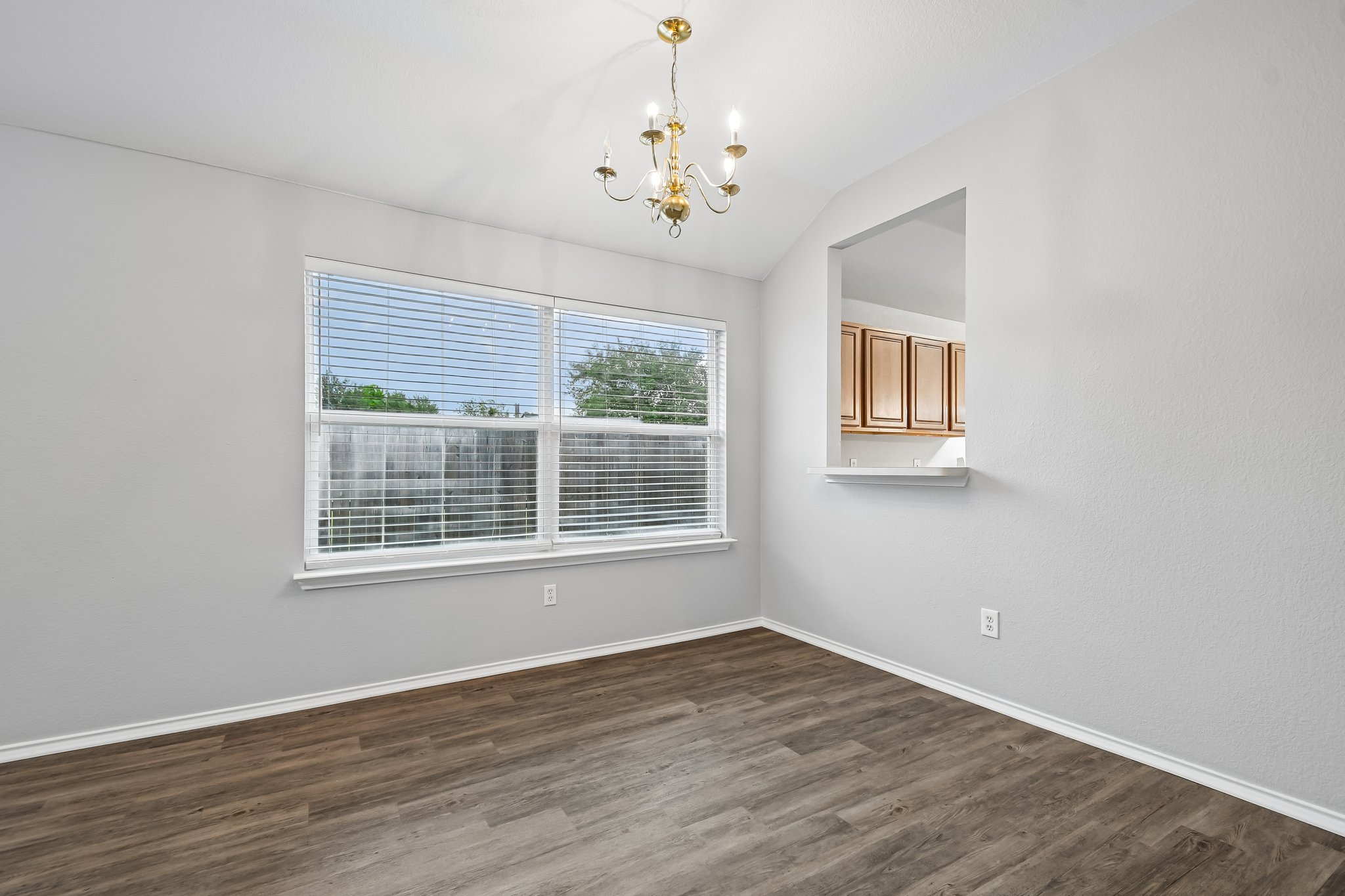 205 Cavalry Trail Elgin, TX 78621 - Photo 10 of 32 a view of an empty room with wooden floor and a window