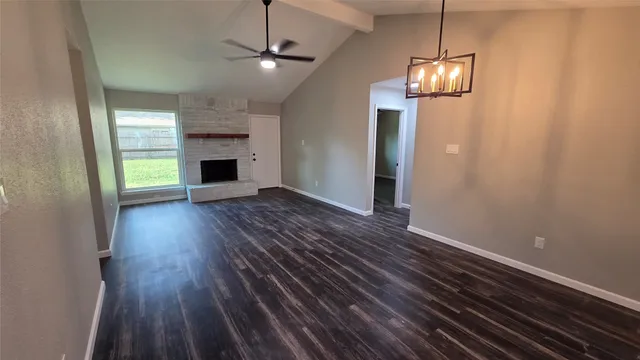 a view of a room with wooden floor and a kitchen