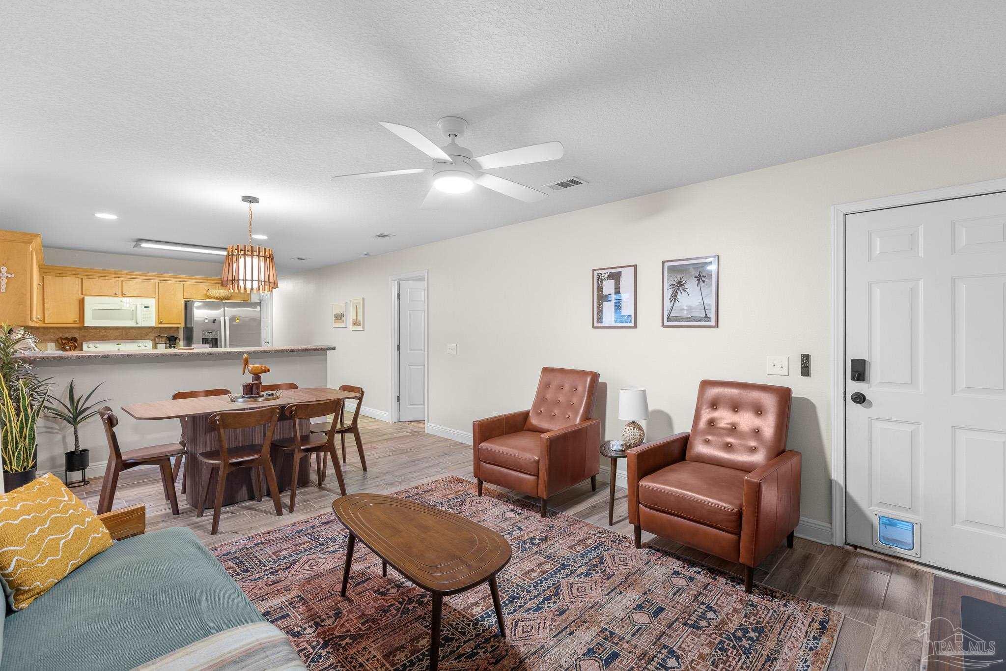 3963 Edgefield Street Pace, FL 32571 - Photo 19 of 30 a living room with furniture kitchen view and a chandelier