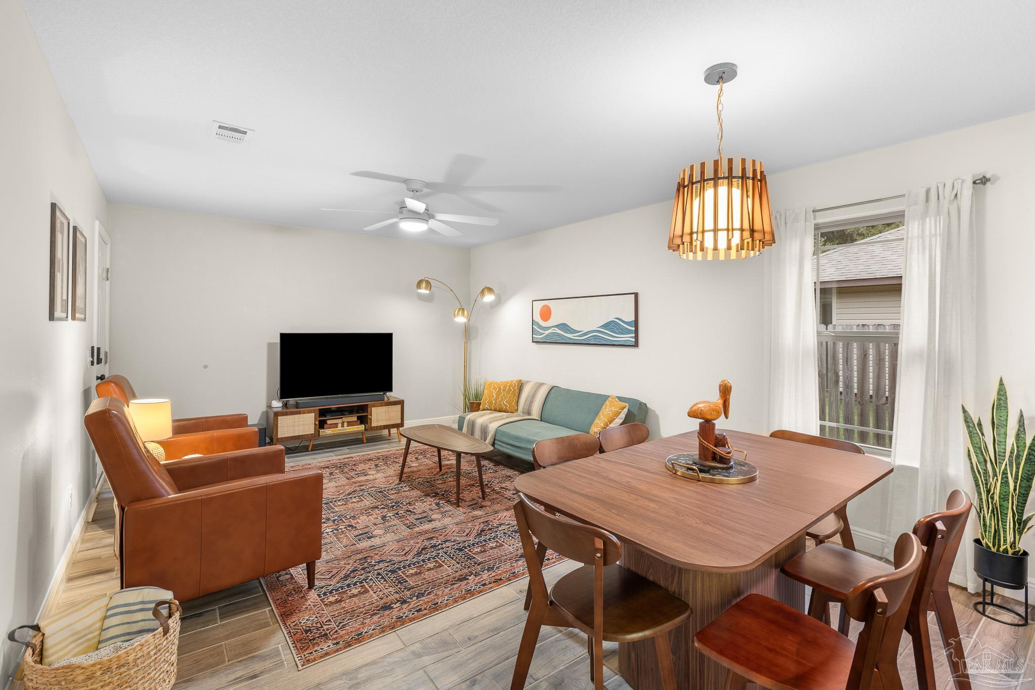 3963 Edgefield Street Pace, FL 32571 - Photo 3 of 30 a view of a livingroom and dining room with furniture wooden floor a chandelier