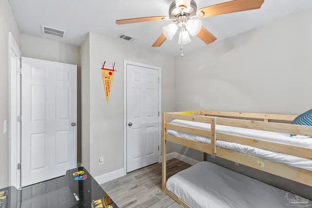 a room with a bed and a chandelier fan