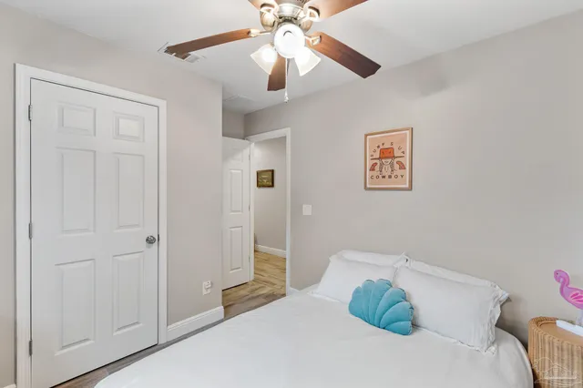 a bedroom with a bed and a ceiling fan